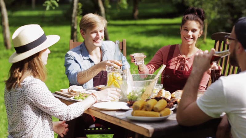 Glückliche Freunde, die am Sommergartenfest zu Abend essen