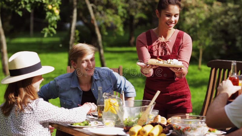 Glückliche Freunde, die am Sommergartenfest zu Abend essen