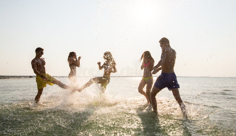 Glückliche Freunde, die Spaß auf Sommerstrand haben stockbilder