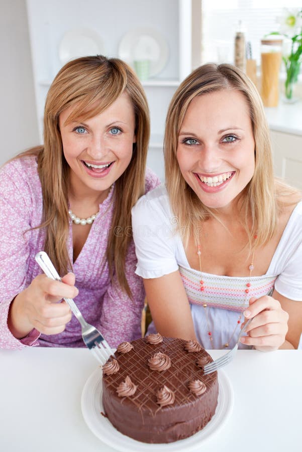 Glückliche Freunde mit einem Kuchen lächelnd an der Kamera stockfotografie Glückliche Freunde mit einem Kuchen lächelnd an der Kamera stockfotografie