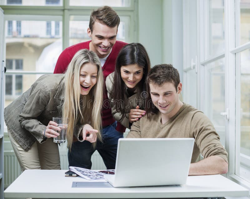 Glückliche Geschäftsleute, die Laptop in der Sitzung verwenden lizenzfreie stockfotografie Glückliche Geschäftsleute, die Laptop in der Sitzung verwenden lizenzfreie stockfotografie