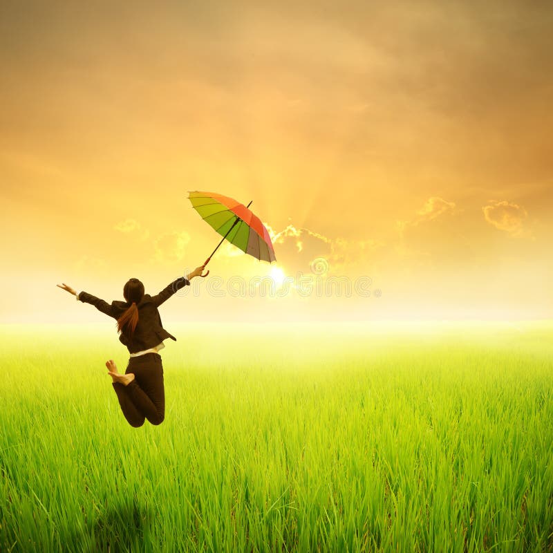 Relax umbrella woman jumping in green rice field and sunset. Relax umbrella woman jumping in green rice field and sunset