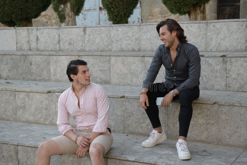 Glückliche homosexuelle Paare, die einen Tourismustag sitzen und genießen lizenzfreie stockfotos