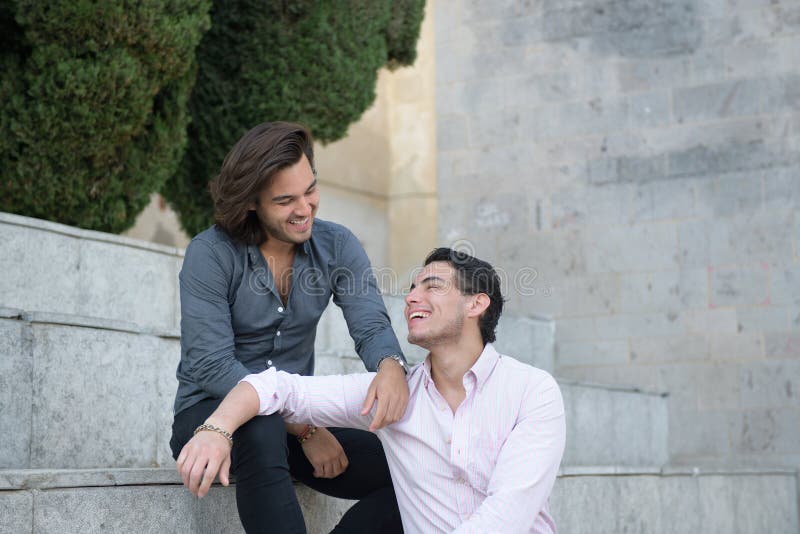 Glückliche homosexuelle Paare, die einen Tourismustag sitzen und genießen stockbilder