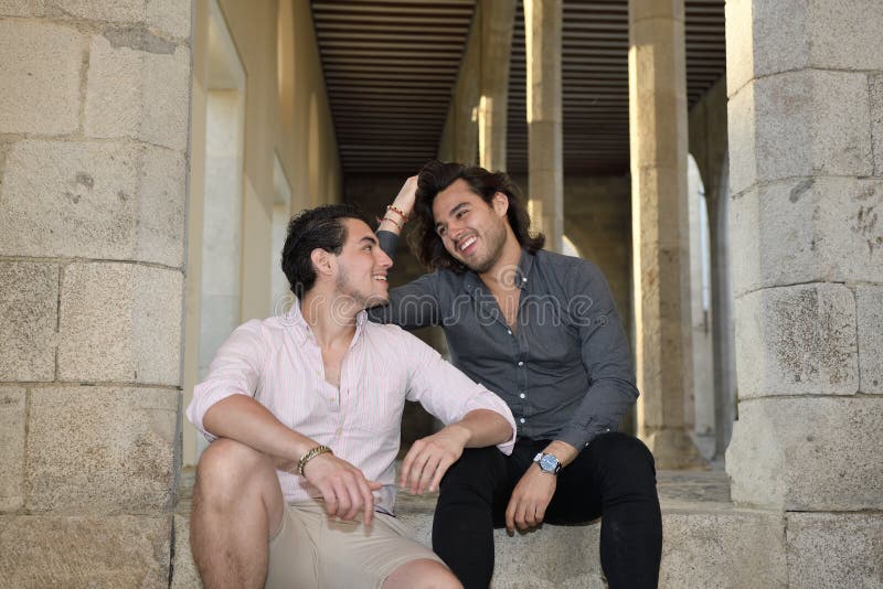 Glückliche homosexuelle Paare, die einen Tourismustag sitzen und genießen stockbilder