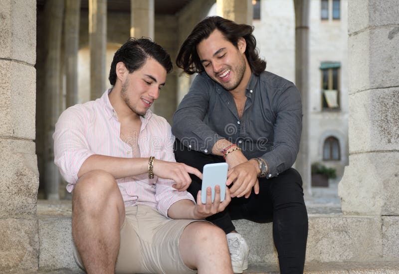 Glückliche homosexuelle Paare mit ihrem Handy stockfotografie