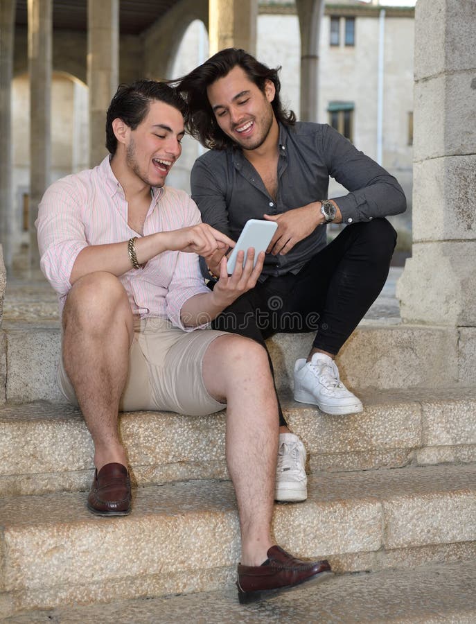 Glückliche homosexuelle Paare mit ihrem Handy stockfotografie