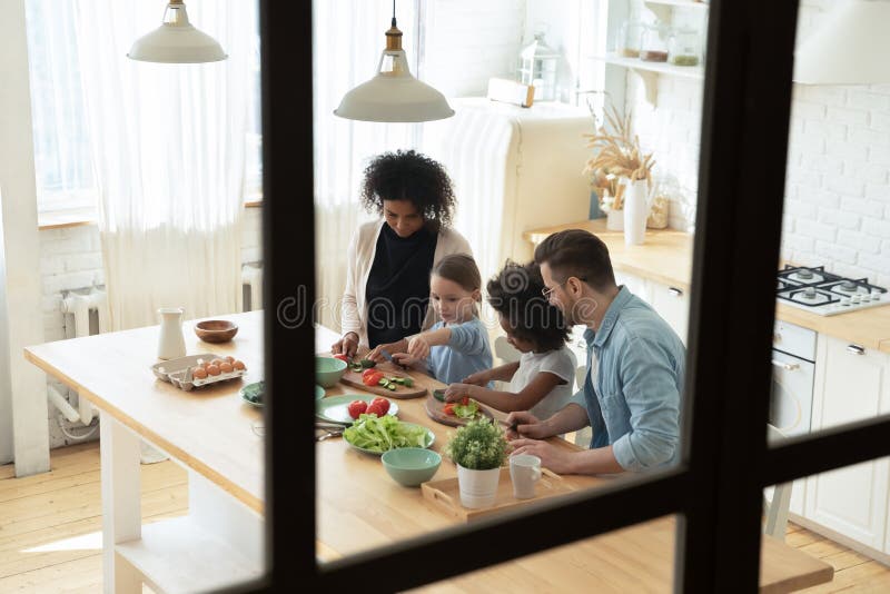 Glückliche internationale Familie beteiligt, mit der in Gebäuden kochen.. lizenzfreie stockbilder