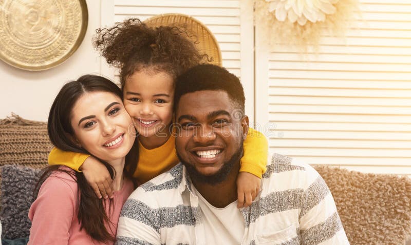 Glückliche internationale Familie umarmt und zu Hause bleibt lizenzfreie stockbilder