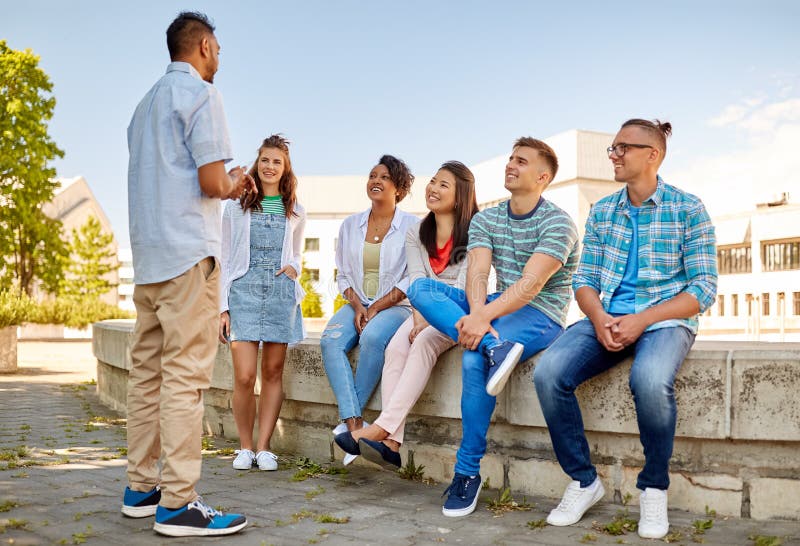 Glückliche internationale Freunde, die in der Stadt sprechen stockfotos