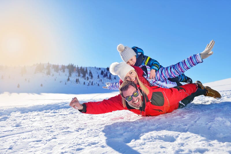 Glückliche junge Familie, die im frischen Schnee am schönen sonnigen Wintertag im Freien in der Natur spielt lizenzfreie stockfotos Glückliche junge Familie, die im frischen Schnee am schönen sonnigen Wintertag im Freien in der Natur spielt lizenzfreie stockfotos