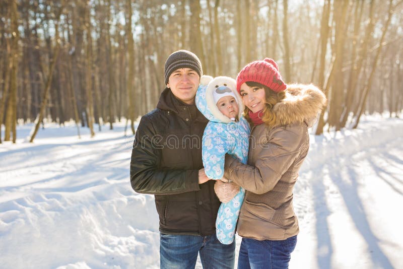 Glückliche junge Familie, welche die Zeit im Freien im Winter verbringt lizenzfreie stockfotos Glückliche junge Familie, welche die Zeit im Freien im Winter verbringt lizenzfreie stockfotos