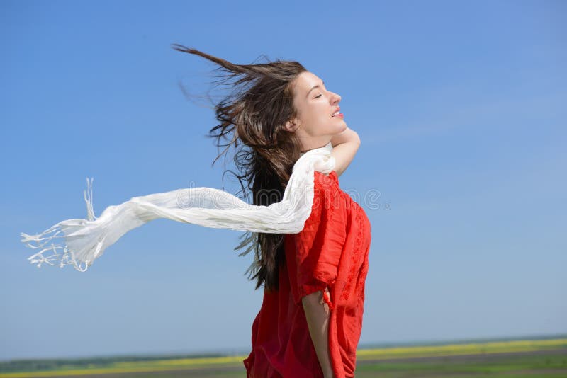 Glückliche junge Frau, die weißen Schal mit den geöffneten Armen ausdrücken Freiheit, Außenaufnahme gegen blauen Himmel hält lizenzfreie stockfotografie Glückliche junge Frau, die weißen Schal mit den geöffneten Armen ausdrücken Freiheit, Außenaufnahme gegen blauen Himmel hält lizenzfreie stockfotografie