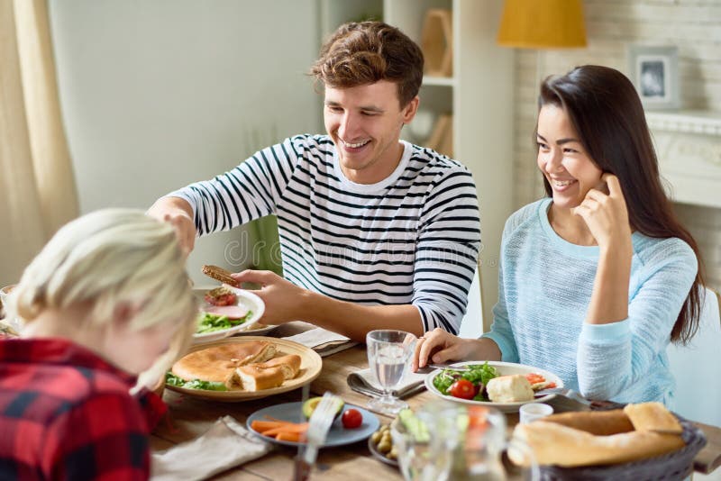 Glückliche junge Paare am Abendtische stockbild Glückliche junge Paare am Abendtische stockbild