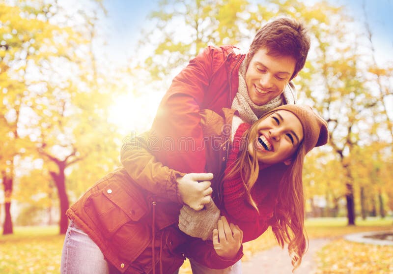 Glückliche junge Paare, die im Herbstpark umarmen lizenzfreies stockfoto Glückliche junge Paare, die im Herbstpark umarmen lizenzfreies stockfoto
