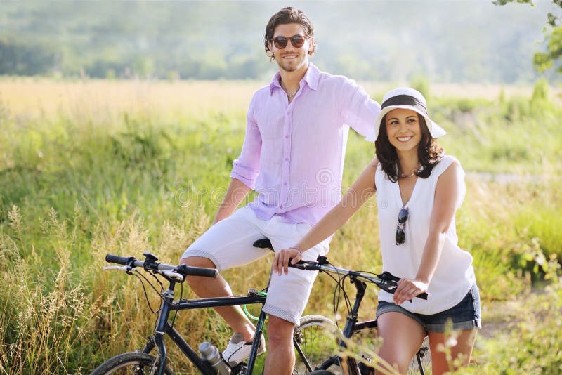 Happy young couple with bicycles in the countryside , focus on men . Holidays and relax. Happy young couple with bicycles in the countryside , focus on men . Holidays and relax
