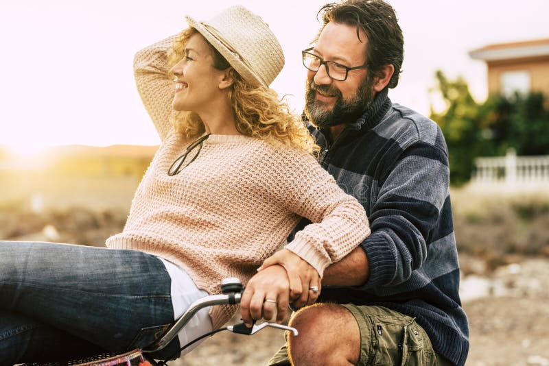 Glückliche junge Paare tragen Frau des Fahrradfahrmannes zusammen kommen, und beide Lachen und den Spaß aktiv und die frohen Natur lizenzfreies stockbild