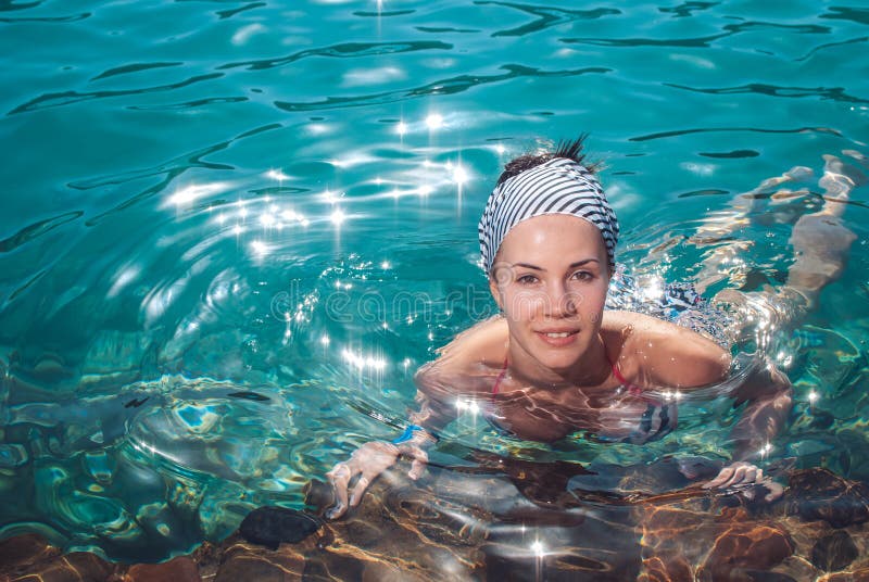 Glückliche, junge und schöne lächelnde Mädchenschwimmen im Meer stockbild Glückliche, junge und schöne lächelnde Mädchenschwimmen im Meer stockbild