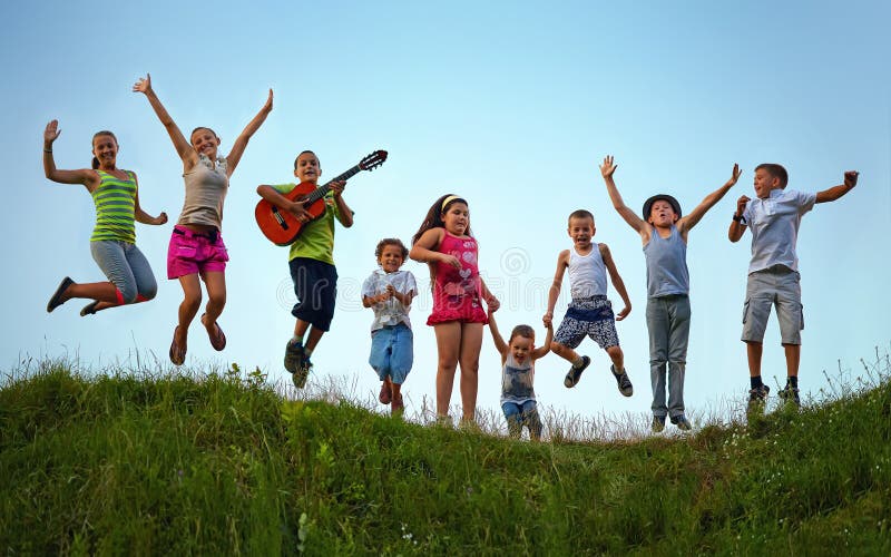 Glückliche Kinder, die auf Sommerfeld springen