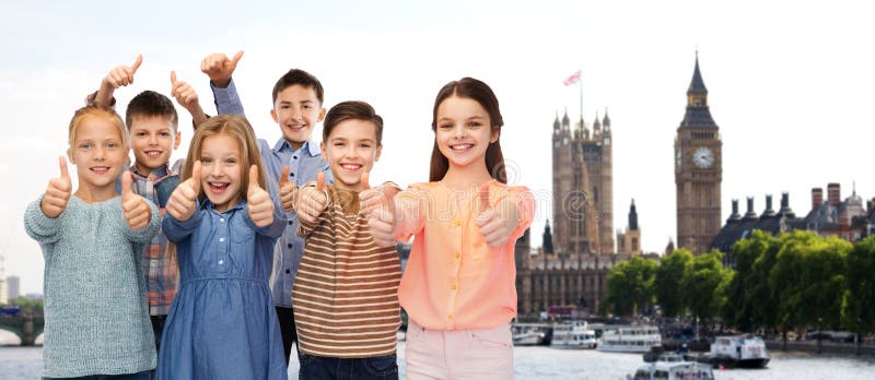 Glückliche Kinder, die Daumen oben über London zeigen lizenzfreies stockbild Glückliche Kinder, die Daumen oben über London zeigen lizenzfreies stockbild