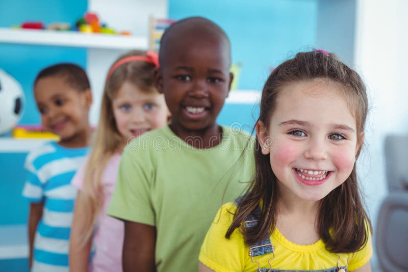 Glückliche Kinder, die in einer Linie stehen lizenzfreie stockfotos Glückliche Kinder, die in einer Linie stehen lizenzfreie stockfotos