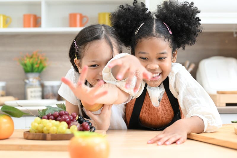 Glückliche Kinder, die mit Mehl spielen und in der Küche lachen stockbild