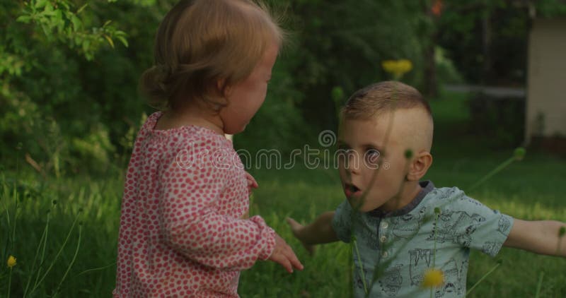 Glückliche Kinder haben Spaß im Sommerpark. kleine Kinder haben Spaß im Sommerpark stock footage