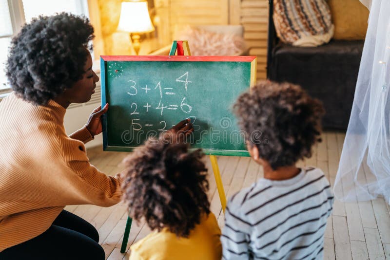 Glückliche Kinder lernen Mathematik mit Mutterlehrer zu Hause. Konzept für das Glück der Familie lizenzfreies stockbild
