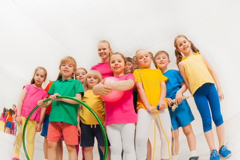 Glückliche Kinder und weibliche Gymnastik trainieren in der Turnhalle lizenzfreie stockbilder Glückliche Kinder und weibliche Gymnastik trainieren in der Turnhalle lizenzfreie stockbilder