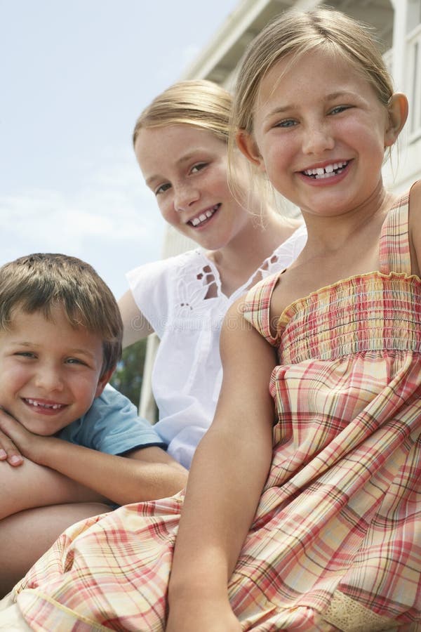 Glückliche kleine Geschwister, die zusammen sitzen lizenzfreies stockfoto Glückliche kleine Geschwister, die zusammen sitzen lizenzfreies stockfoto