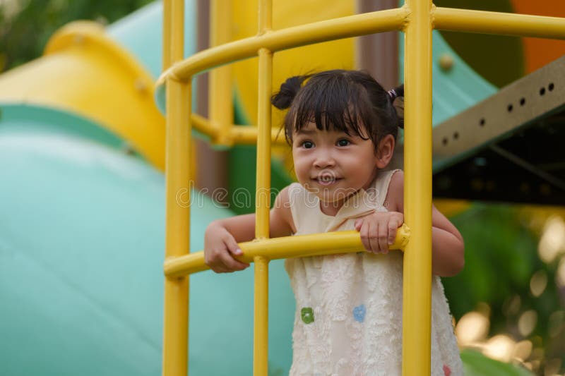Glückliche Kleinkind, die auf dem Spielplatz im Park spielen und klettern lizenzfreies stockbild