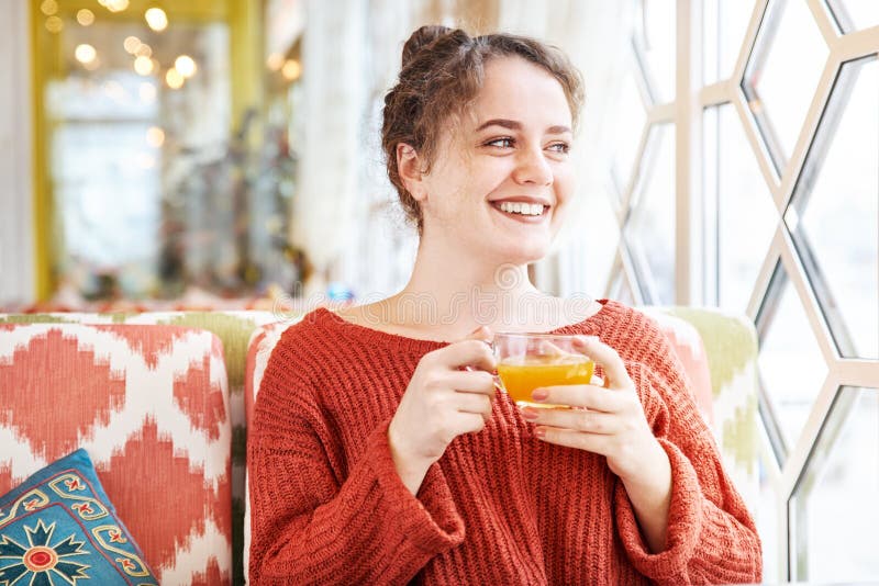 Glückliche lachende junge Rothaarigefrau, die in einem Café früh morgens mit einer Schale frühstückt lizenzfreies stockbild Glückliche lachende junge Rothaarigefrau, die in einem Café früh morgens mit einer Schale frühstückt lizenzfreies stockbild