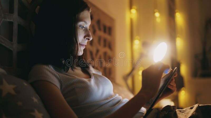 Glückliche lächelnde Frau, die Tablet-Computer für das Teilen des Social Media zu Hause liegt im Bett nachts verwendet lizenzfreie stockfotos Glückliche lächelnde Frau, die Tablet-Computer für das Teilen des Social Media zu Hause liegt im Bett nachts verwendet lizenzfreie stockfotos