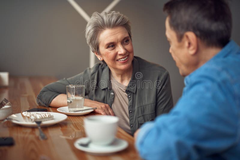 Glückliche lächelnde gealterte Paare, die im Café sitzen lizenzfreies stockfoto Glückliche lächelnde gealterte Paare, die im Café sitzen lizenzfreies stockfoto