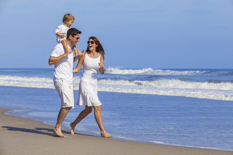 Glückliche Mann-Frauen-Kinderfamilie, die auf Strand spielt lizenzfreies stockfoto