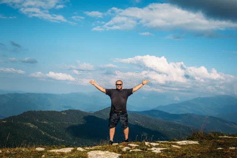 Glückliche Manngeste des Triumphes mit den Armen in einer Luft am Gebirgstal-Landschaftshintergrund stockbild Glückliche Manngeste des Triumphes mit den Armen in einer Luft am Gebirgstal-Landschaftshintergrund stockbild