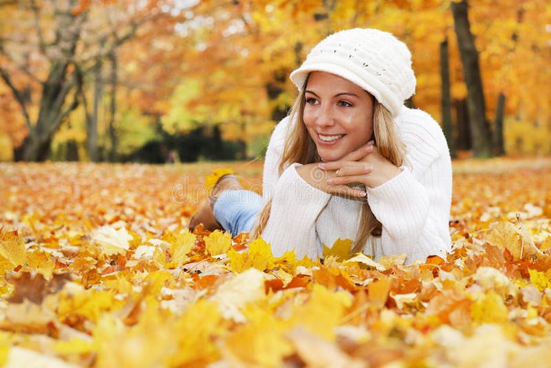 Glückliche Mittelalterfrau mit dem Schal und Kappe, die im Herbst sich entspannen stockfotos Glückliche Mittelalterfrau mit dem Schal und Kappe, die im Herbst sich entspannen stockfotos