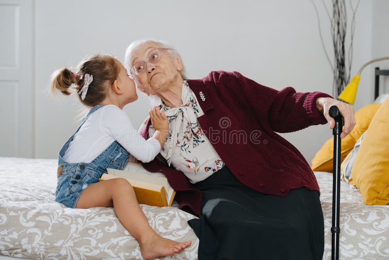 Glückliche Momente Wenig Mädchen mit ihrer großen Großmutterausgaben-Qualitätszeit zusammen lizenzfreies stockfoto Glückliche Momente Wenig Mädchen mit ihrer großen Großmutterausgaben-Qualitätszeit zusammen lizenzfreies stockfoto