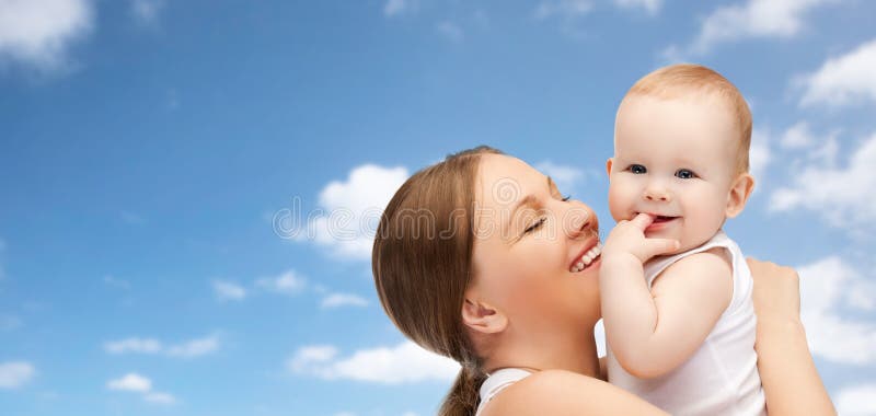 Glückliche Mutter, die entzückendes Baby über blauem Himmel hält lizenzfreies stockbild Glückliche Mutter, die entzückendes Baby über blauem Himmel hält lizenzfreies stockbild