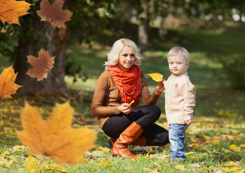 Glückliche Mutter und Kind, die zusammen am warmen Herbsttag spielt stockbilder Glückliche Mutter und Kind, die zusammen am warmen Herbsttag spielt stockbilder