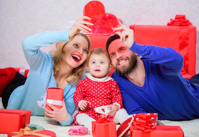 Glückliche Muttergesellschaft Das Leben kann nicht besser sein Familie feiern Jahrestag Verbinden Sie in der Liebe und in der Babytochter Roter heart-shaped Schmucksachegeschenkkasten und eine rote Spule auf einem Zeichen Zusammen am Valentinsgrußtag Reizende Familie, die Valentinsgrußtag feiert