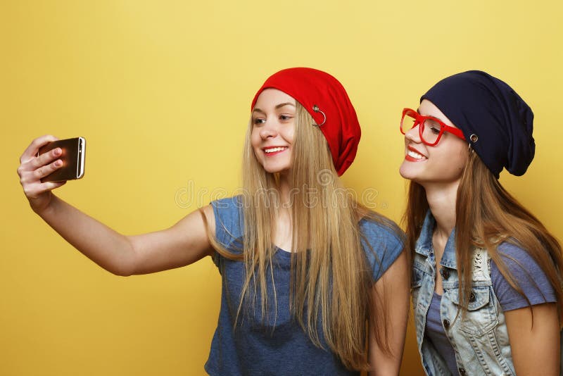 Glückliche Mädchen mit Smartphone über gelbem Hintergrund Glücklicher Selbst lizenzfreie stockbilder Glückliche Mädchen mit Smartphone über gelbem Hintergrund Glücklicher Selbst lizenzfreie stockbilder