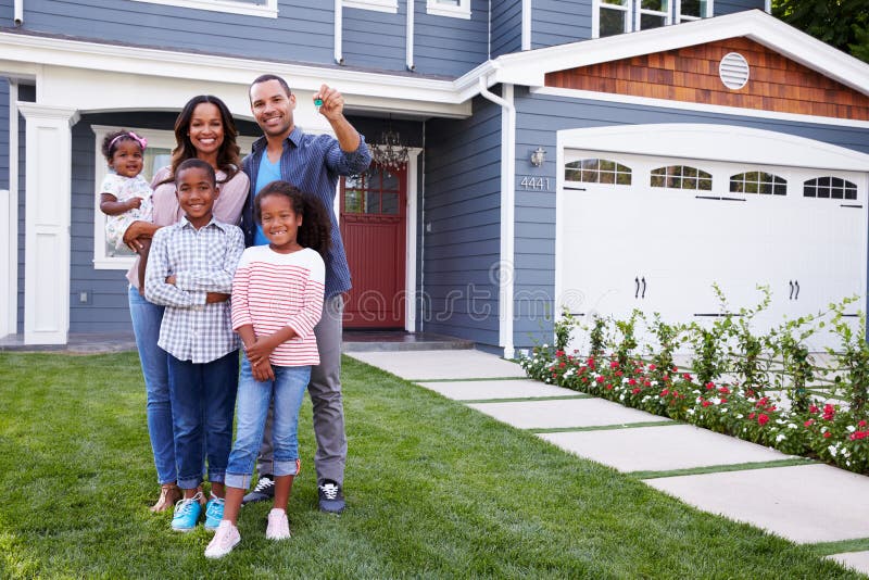 Glückliche schwarze Familie stehend außerhalb ihres Hauses, Vati, der den Schlüssel hält