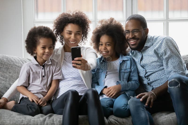 Glückliche Schwarze Familienpaare und zwei Kinder, die selfie nehmen lizenzfreie stockbilder