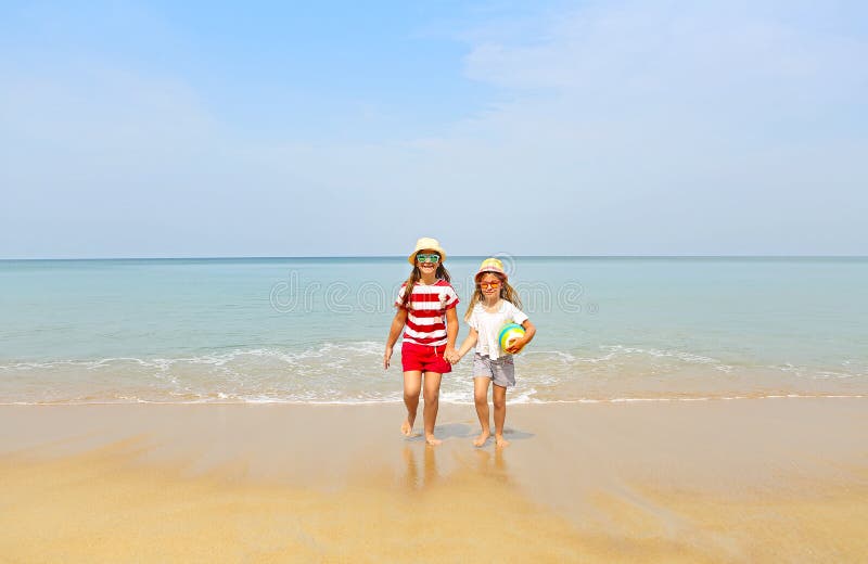 Glückliche Schwestern, die im Sand auf einem schönen Strand spielen lizenzfreie stockfotografie Glückliche Schwestern, die im Sand auf einem schönen Strand spielen lizenzfreie stockfotografie