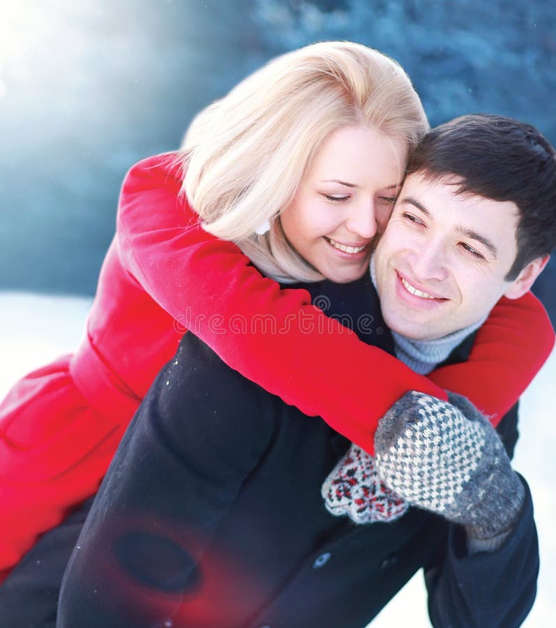 Glückliche schöne liebevolle Paare, die Spaß im Winter haben