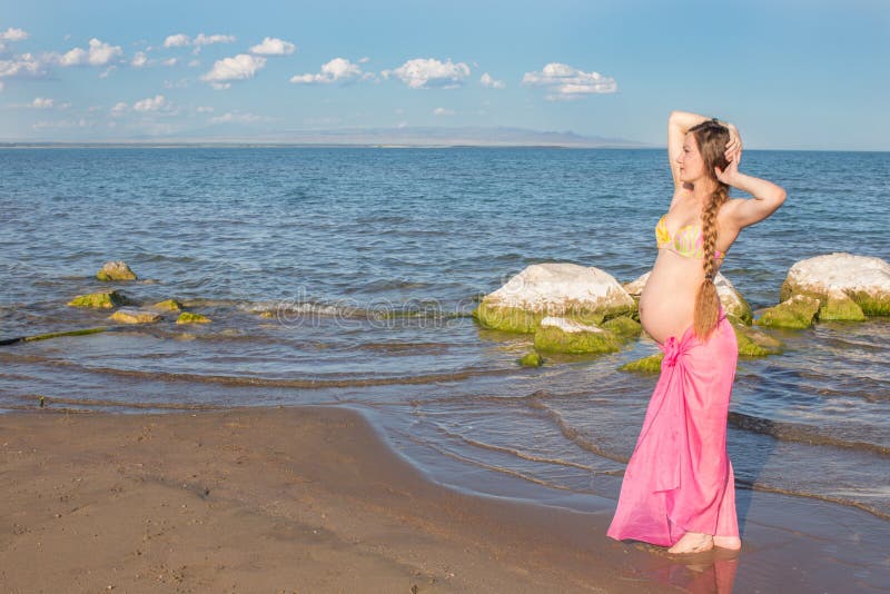 Glückliche schöne schwangere Frau beim Badeanzuggehen lizenzfreie stockfotografie Glückliche schöne schwangere Frau beim Badeanzuggehen lizenzfreie stockfotografie