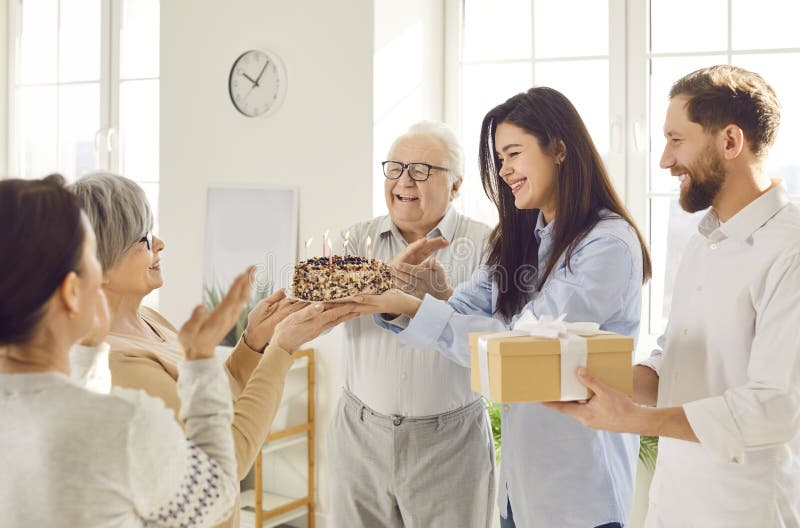 Glückliche Seniorin feiert Geburtstag mit ihrer Familie im Wohnzimmer zu Hause lizenzfreies stockbild
