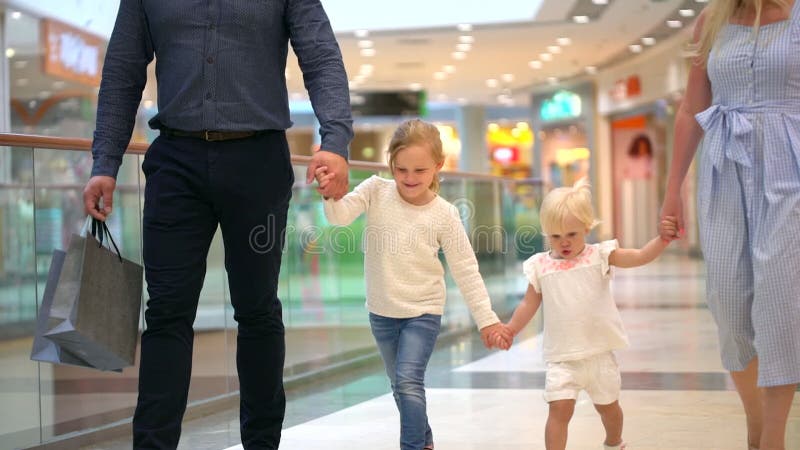 Glückliche vierköpfige Familie, die das Einkaufen tut Familie im Mall Kinder am Mall mit Eltern Familieneinkaufen im Kaufhaus Zwe