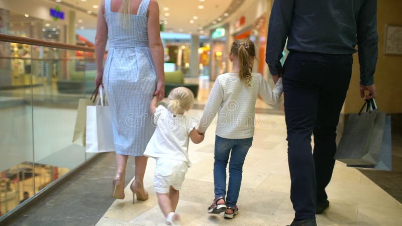 Glückliche vierköpfige Familie, die das Einkaufen tut Familie im Mall Kinder am Mall mit Eltern Familieneinkaufen im Kaufhaus Zwe